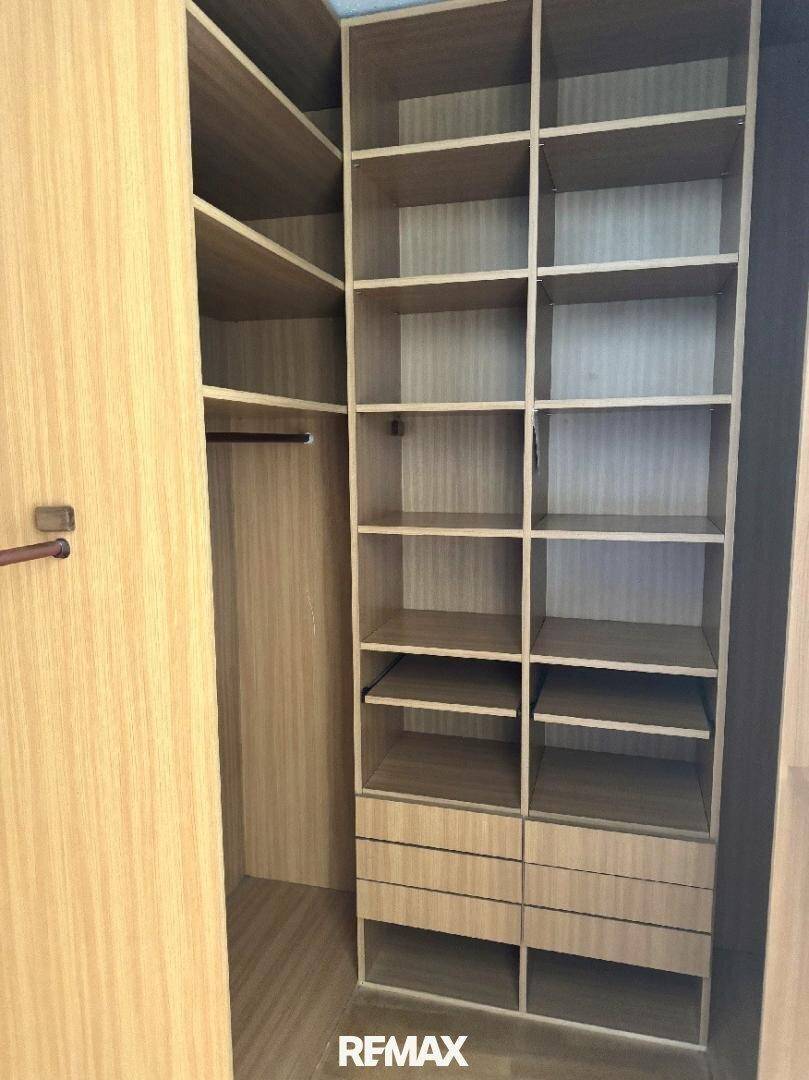 Praktischer begehbarer Kleiderschrank mit vielen Regalen und Schubladen für optimalen Stauraum.