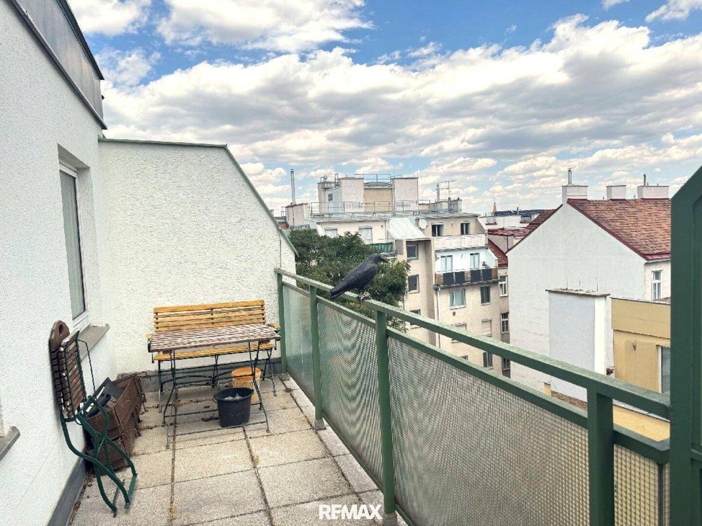 Gemütliche Terrasse mit einfacher Sitzgelegenheit und Panoramablick über die städtische Umgebung.
