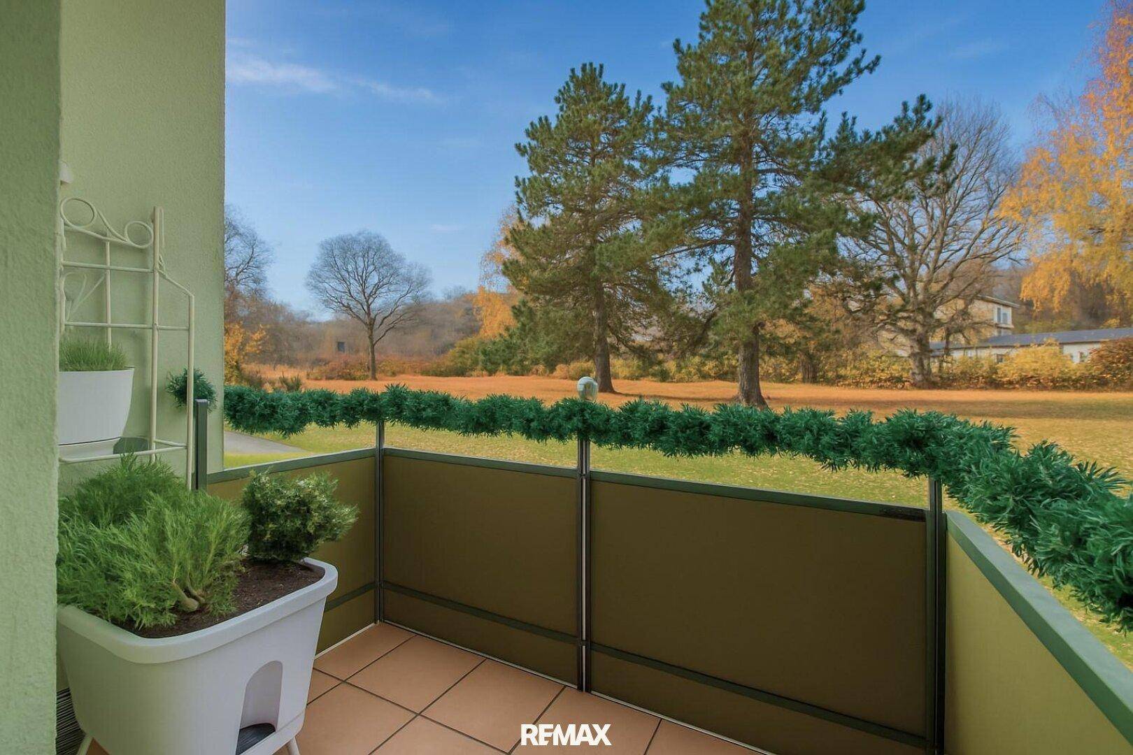 Kleiner Balkon mit Fliesenboden und Blick ins Grüne, ideal zum Entspannen im Freien.