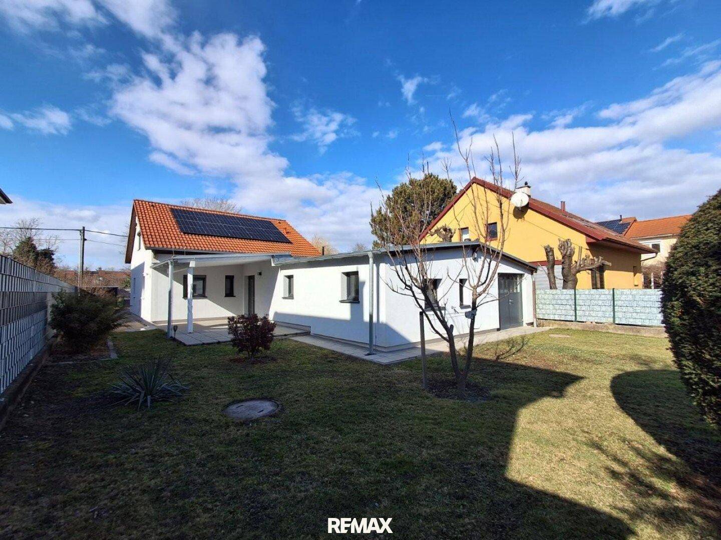 Weitläufiger Garten mit Einfamilienhaus, separatem Nebengebäude und viel Grünfläche.