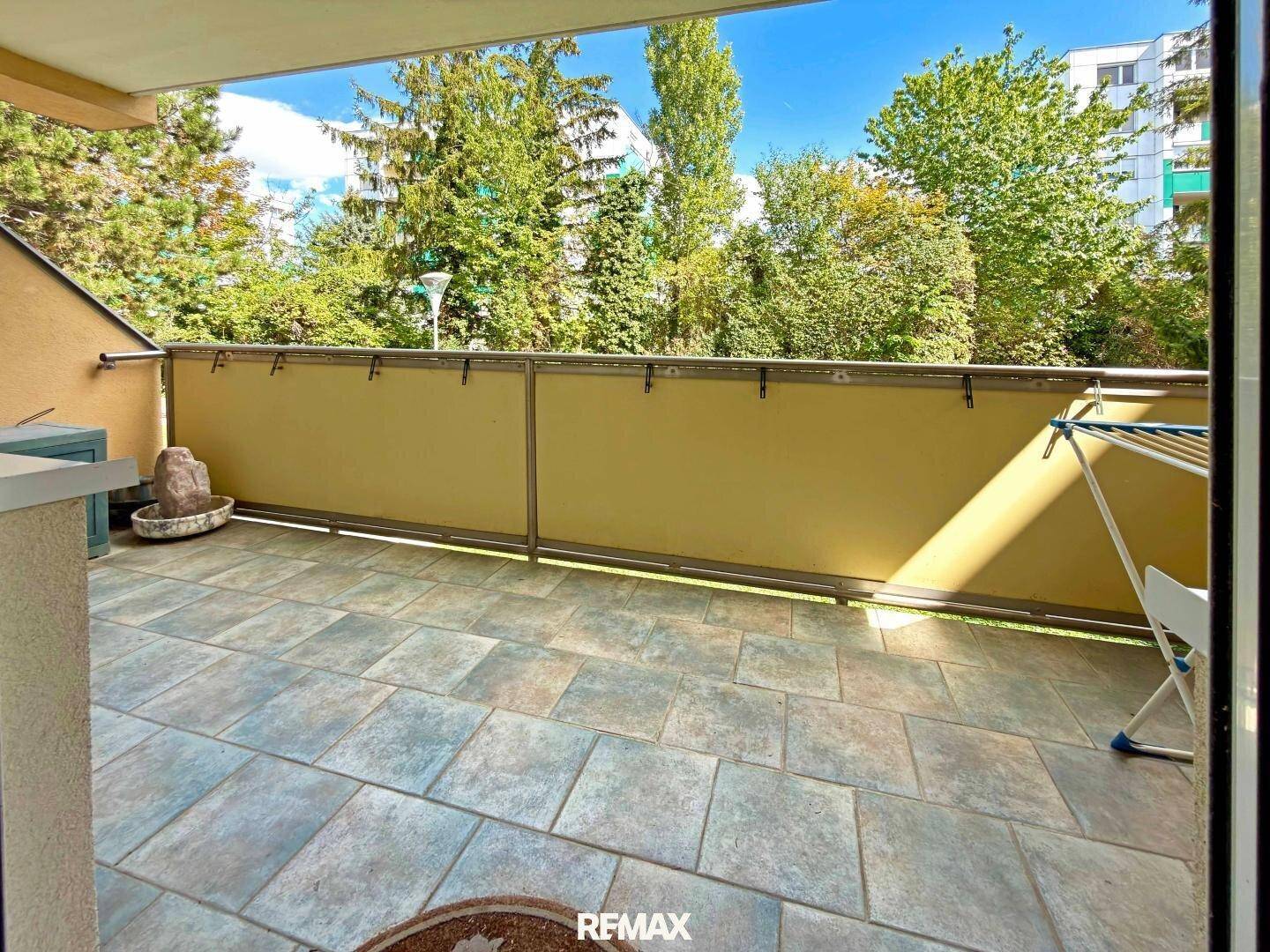 Gefliester Balkon mit Wäscheständer und Blick ins Grüne, ideal zum Entspannen.