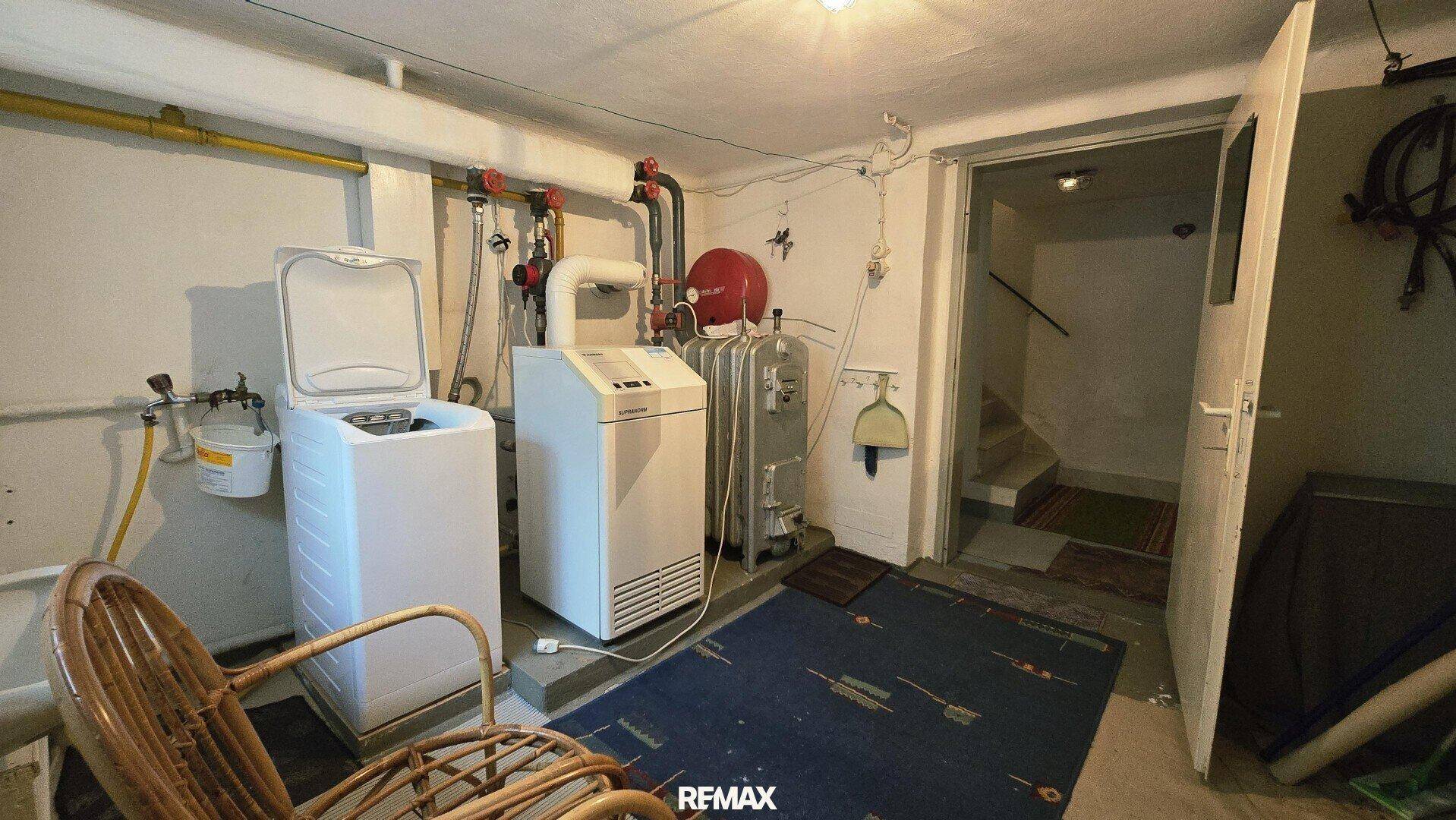 Heizungsraum im Keller mit moderner Heizungsanlage und Warmwasserspeicher.
