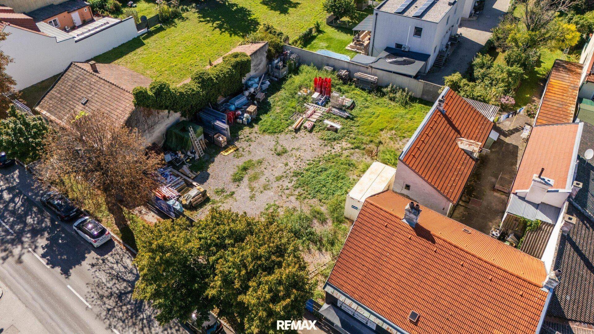 Luftaufnahme eines Grundstücks aus neuer Perspektive, umgeben von Gebäuden und einer belebten Straße.