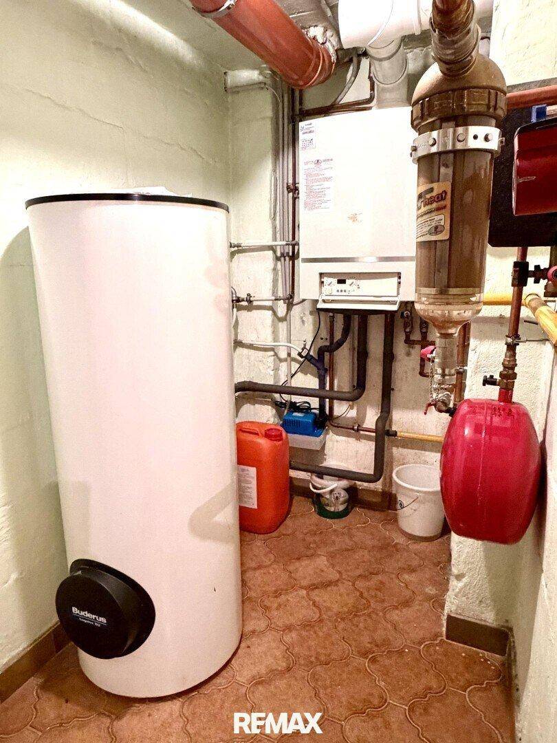 Heizungsraum mit Warmwasserspeicher und Gastherme, funktional und gut zugänglich im Keller.