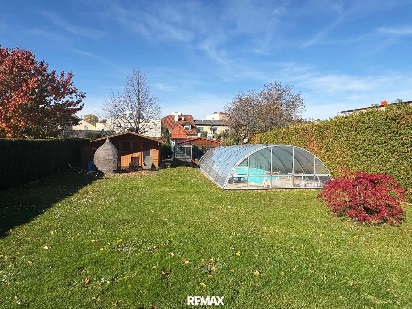 Großer Gartenbereich mit überdachtem Pool und einem praktischen Gartenhaus.