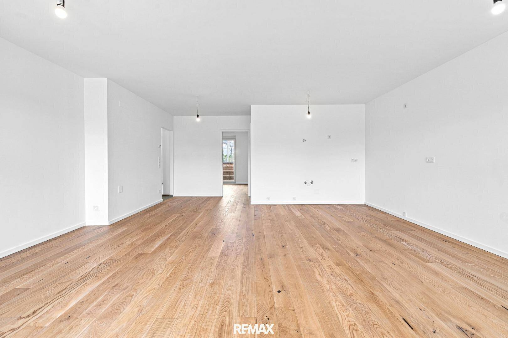 Geräumiger, leerer Wohn-Essbereich mit hochwertigem Holzboden und viel Potenzial.