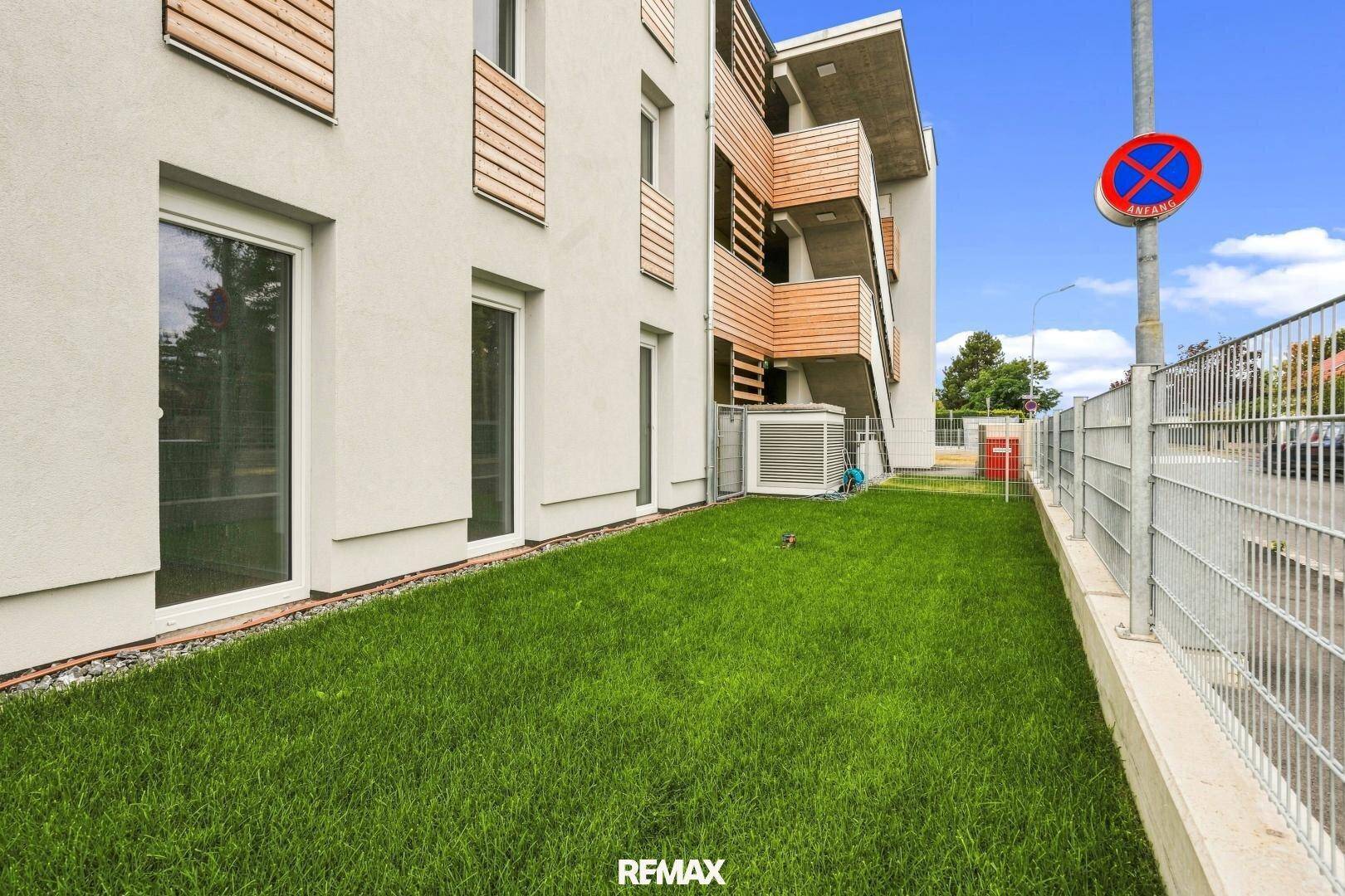 Seitenansicht des Gebäudes mit Grünfläche und moderner Architektur.