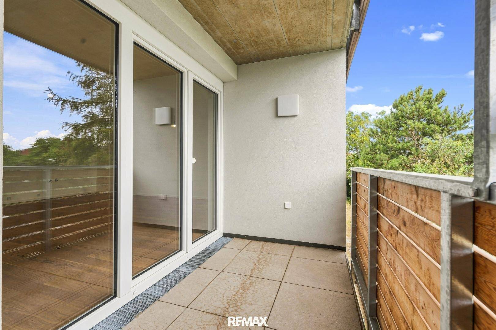 Balkon mit Fliesenboden und Holzverkleidung, bietet einen privaten Außenbereich.