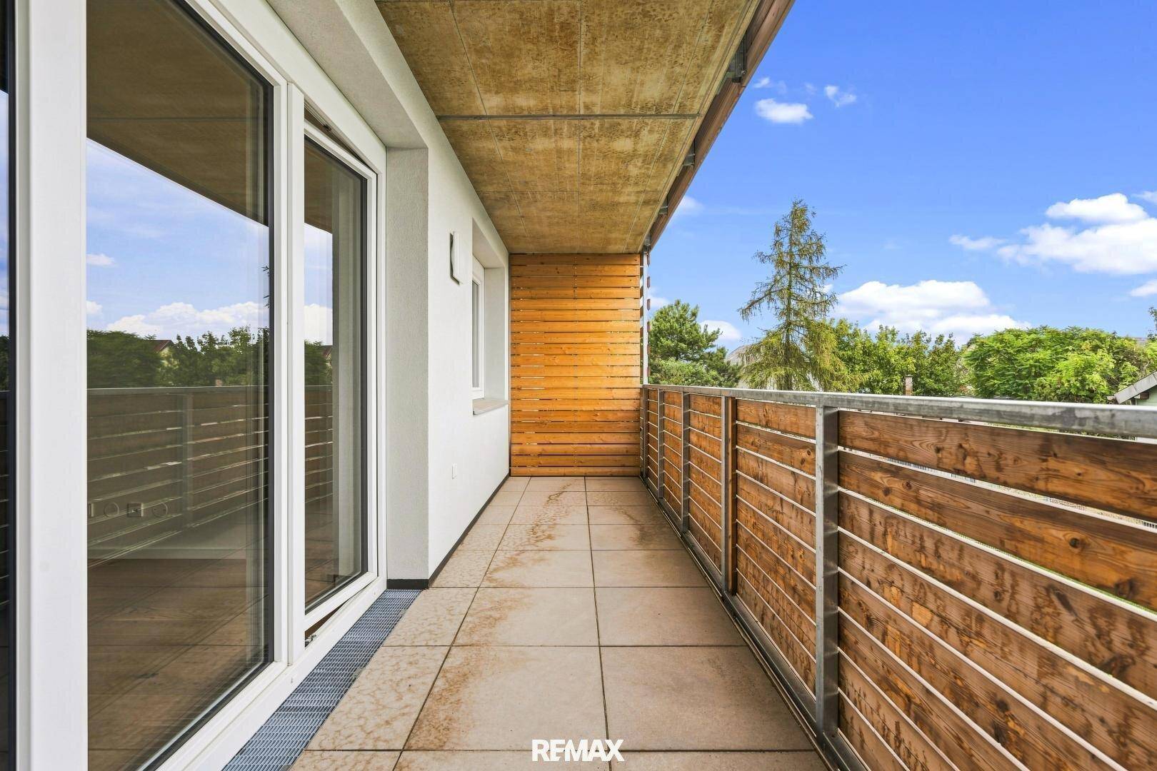 Langer Balkon mit Holzelementen und Fliesenboden, bietet einen angenehmen Außenbereich.