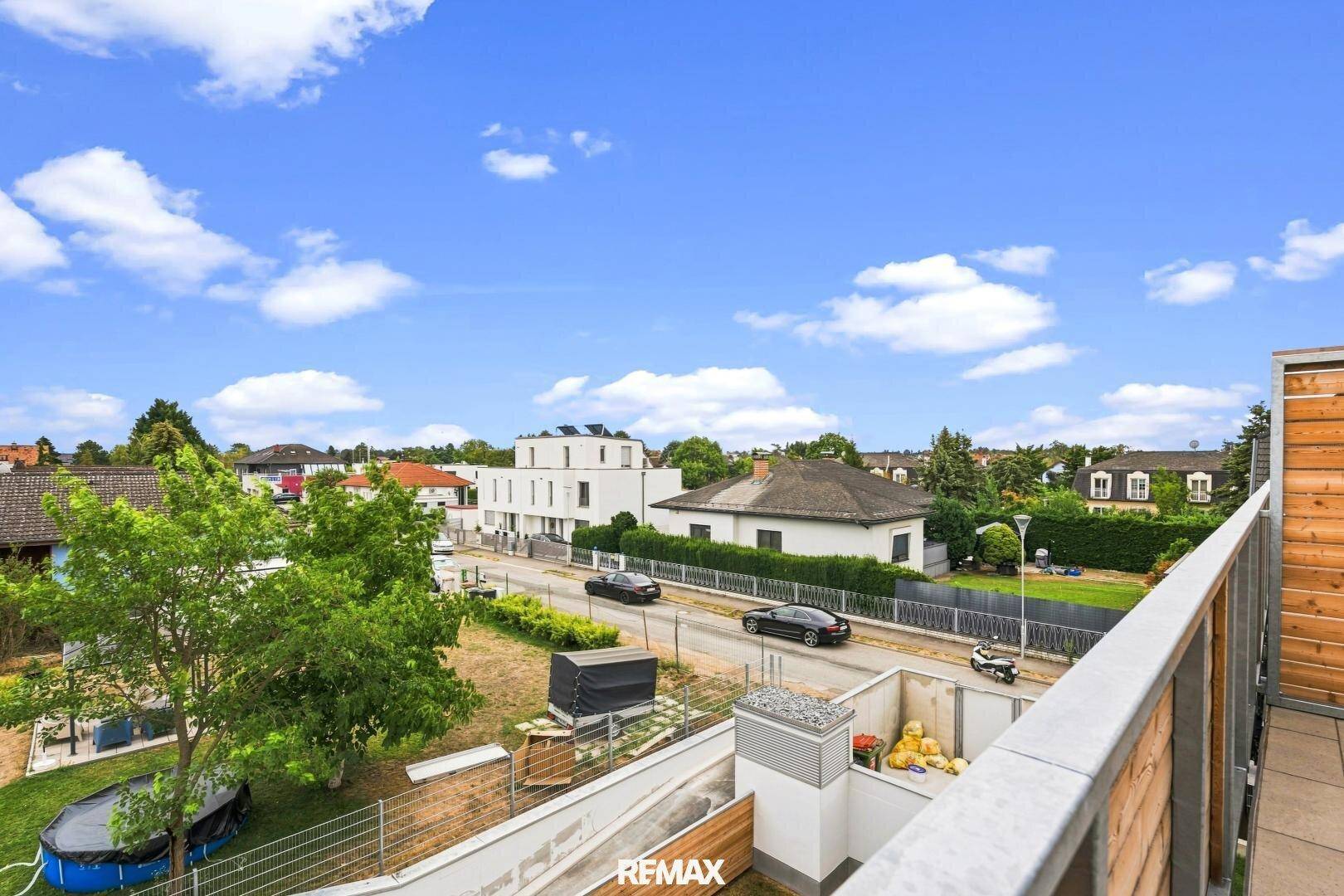 Weitläufiger Blick vom Balkon auf die umliegende Wohngegend und grüne Landschaft.