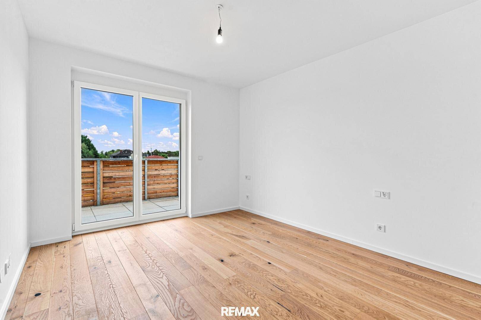 Helles Schlafzimmer mit Holzboden und direktem Zugang zu einer privaten Terrasse.