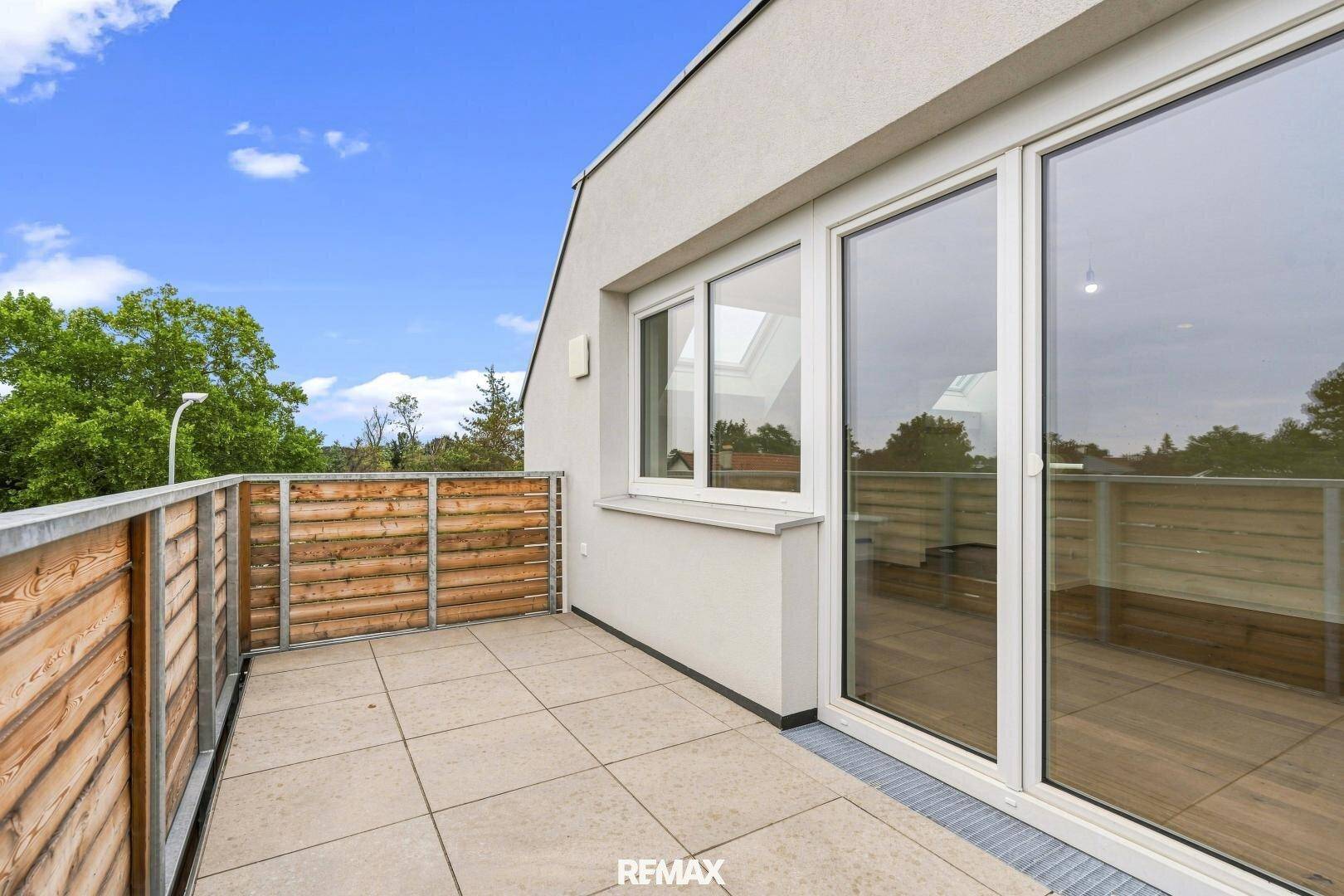 Sonnige Eckterrasse mit großen Fenstern, die viel Licht in die angrenzenden Wohnräume lassen.