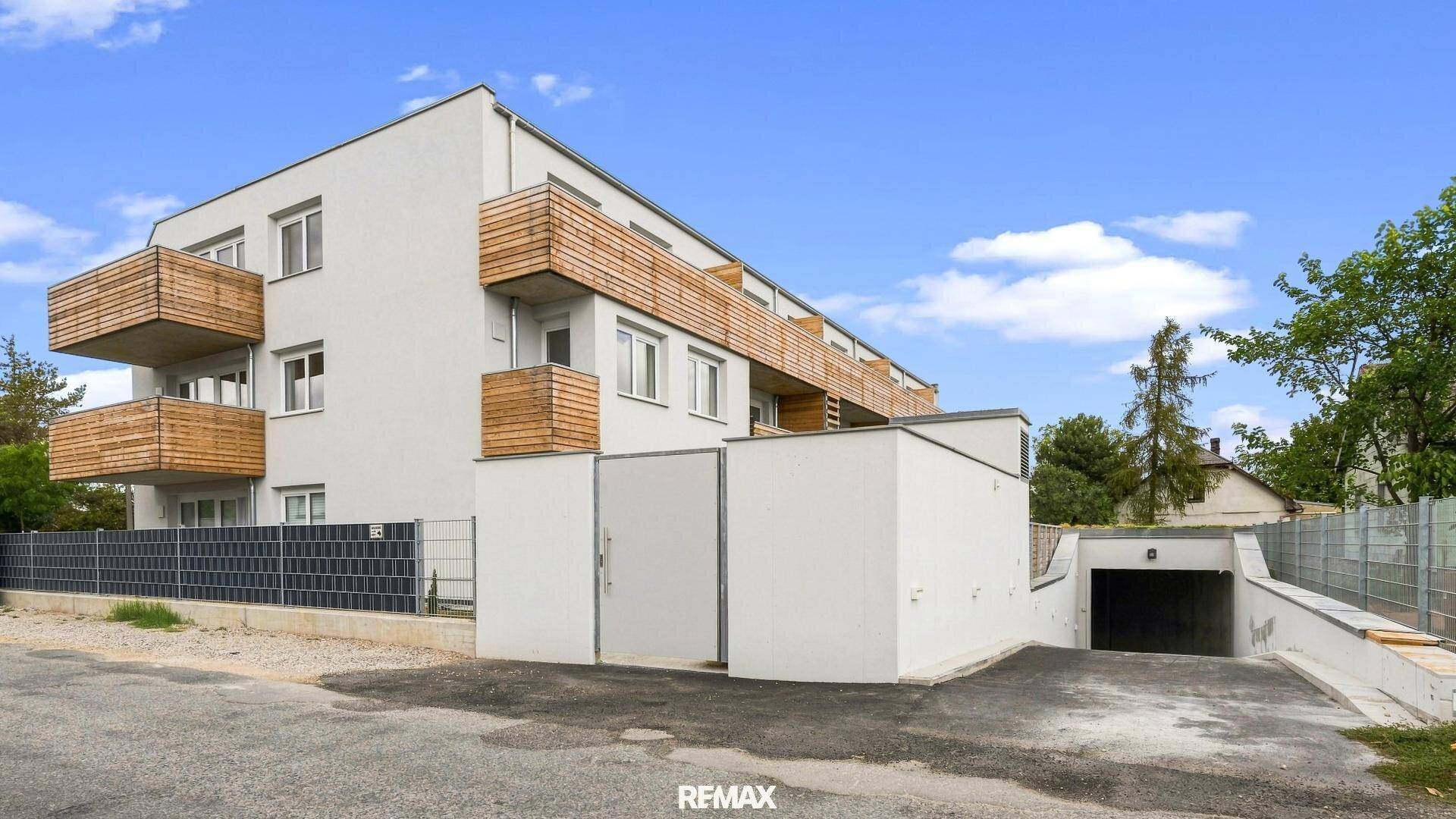 Seitenansicht des Neubaus mit moderner Architektur und dem Zugang zur Tiefgarage.