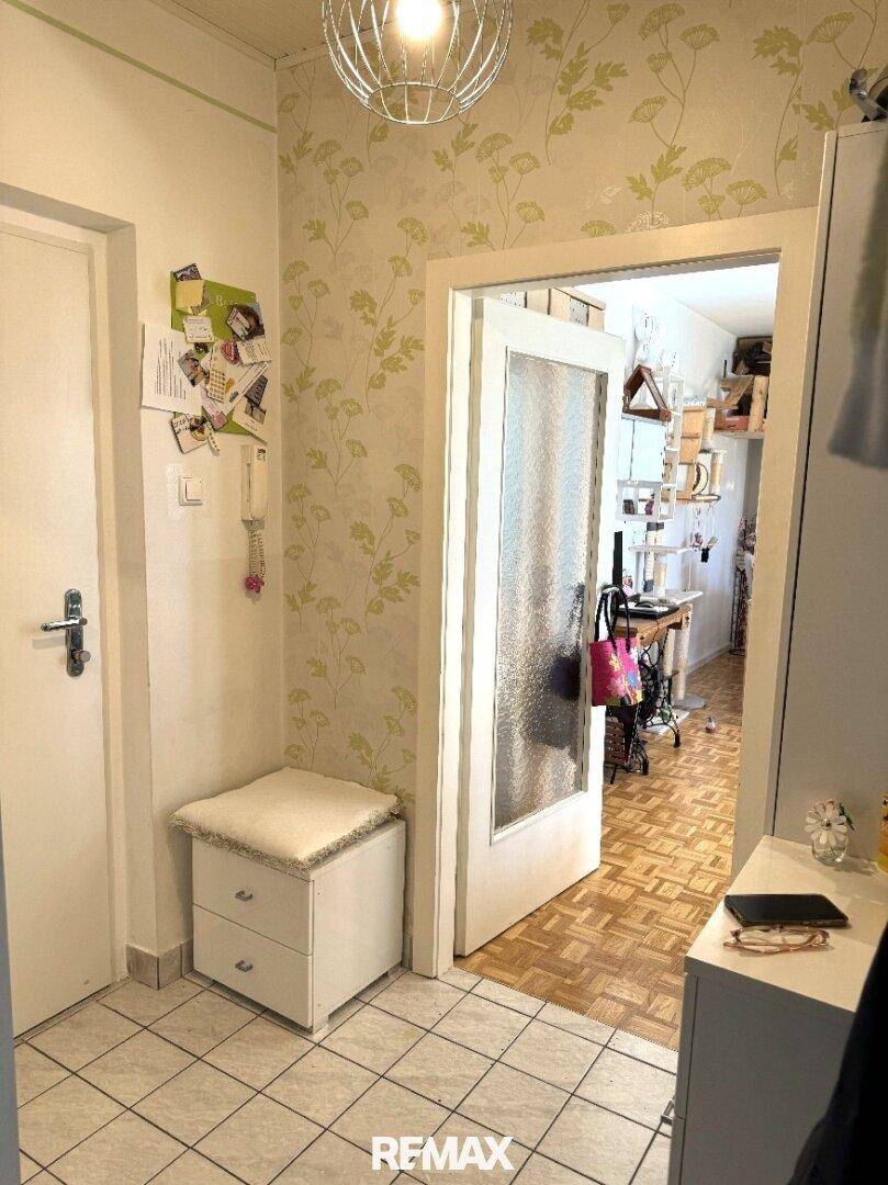 Heller Eingangsbereich mit Fliesenboden, Garderobe und Zugang zu weiteren Räumen.