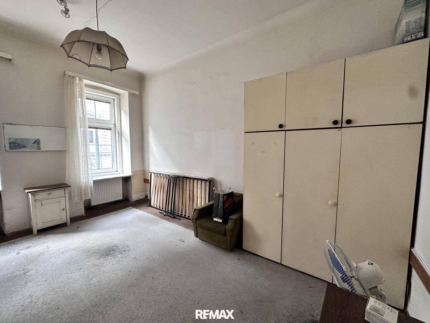 Geräumiges Schlafzimmer mit Teppichboden, großem Kleiderschrank und Blick auf die Straße.