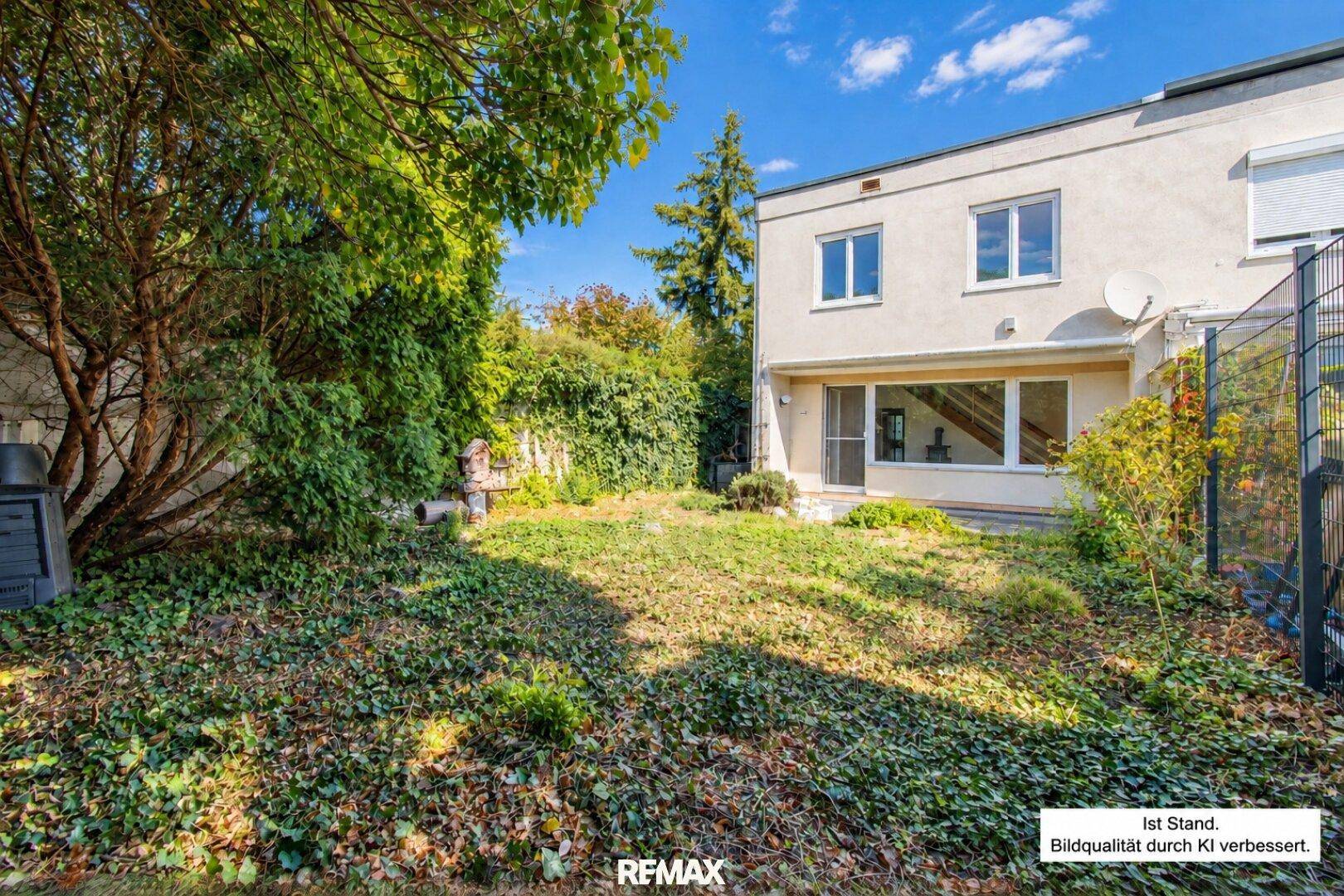 Aktueller Zustand des Hinterhofgartens mit Rasenfläche und Blick auf das Haus.