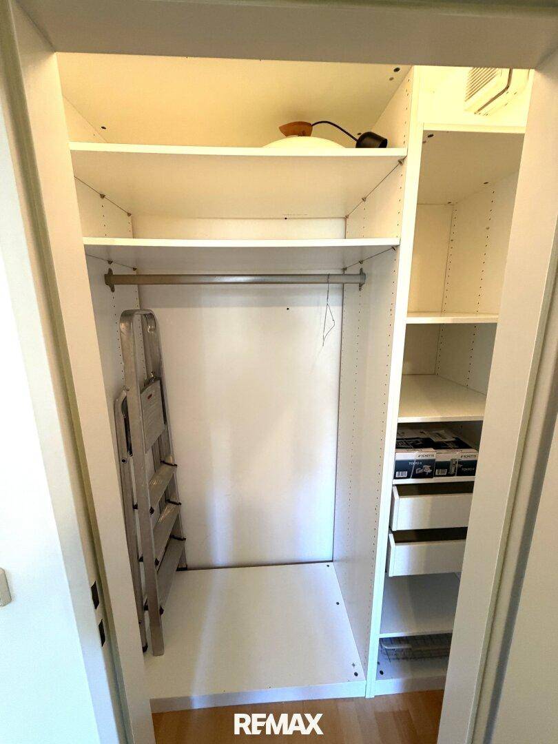 Praktischer Einbauschrank mit Regalen und Kleiderstange für zusätzlichen Stauraum.