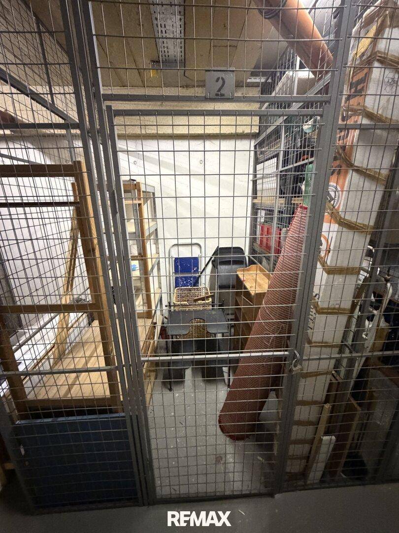 Abgeschlossener Kellerabteil mit Gitterwänden bietet zusätzlichen Stauraum für persönliche Gegenstände.