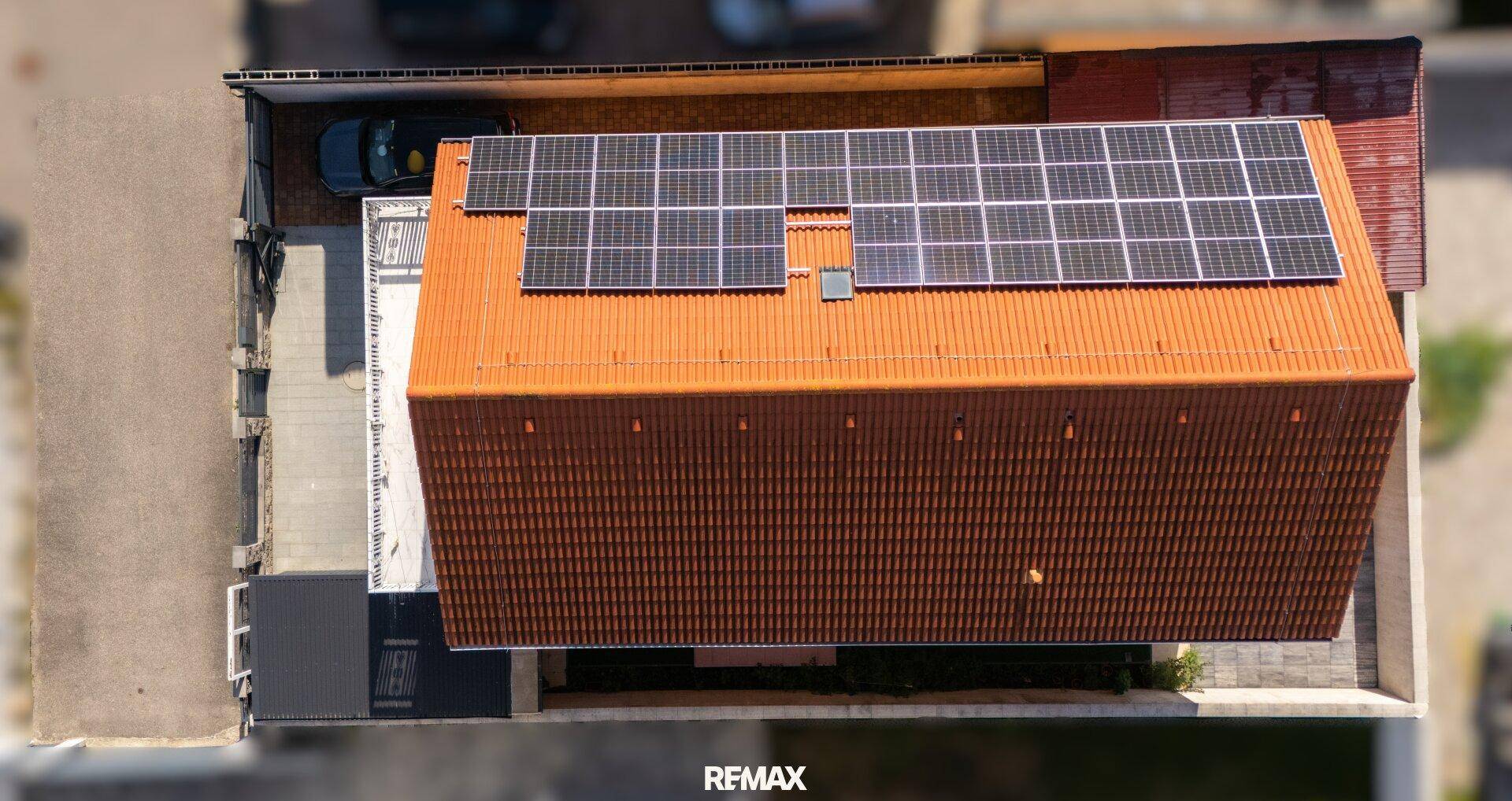 Draufsicht auf das Haus mit umfangreicher Photovoltaikanlage auf dem orangeroten Ziegeldach.