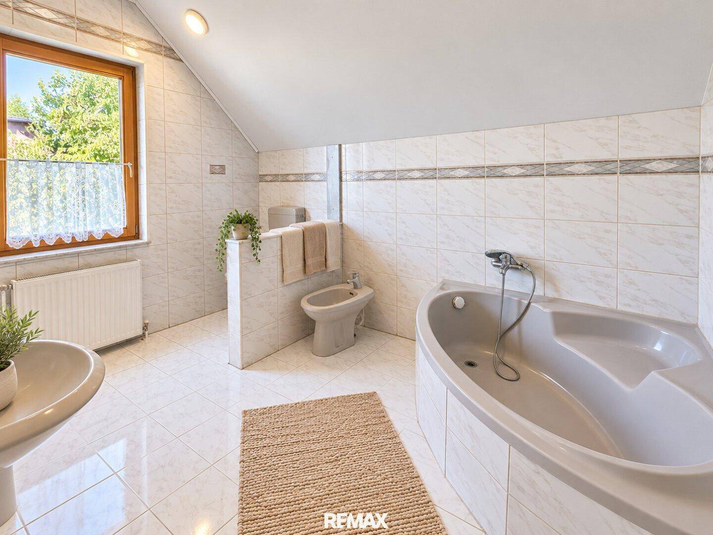 Geräumiges Badezimmer mit Fliesenboden, Eckbadewanne, Bidet und Fenster für Tageslicht.