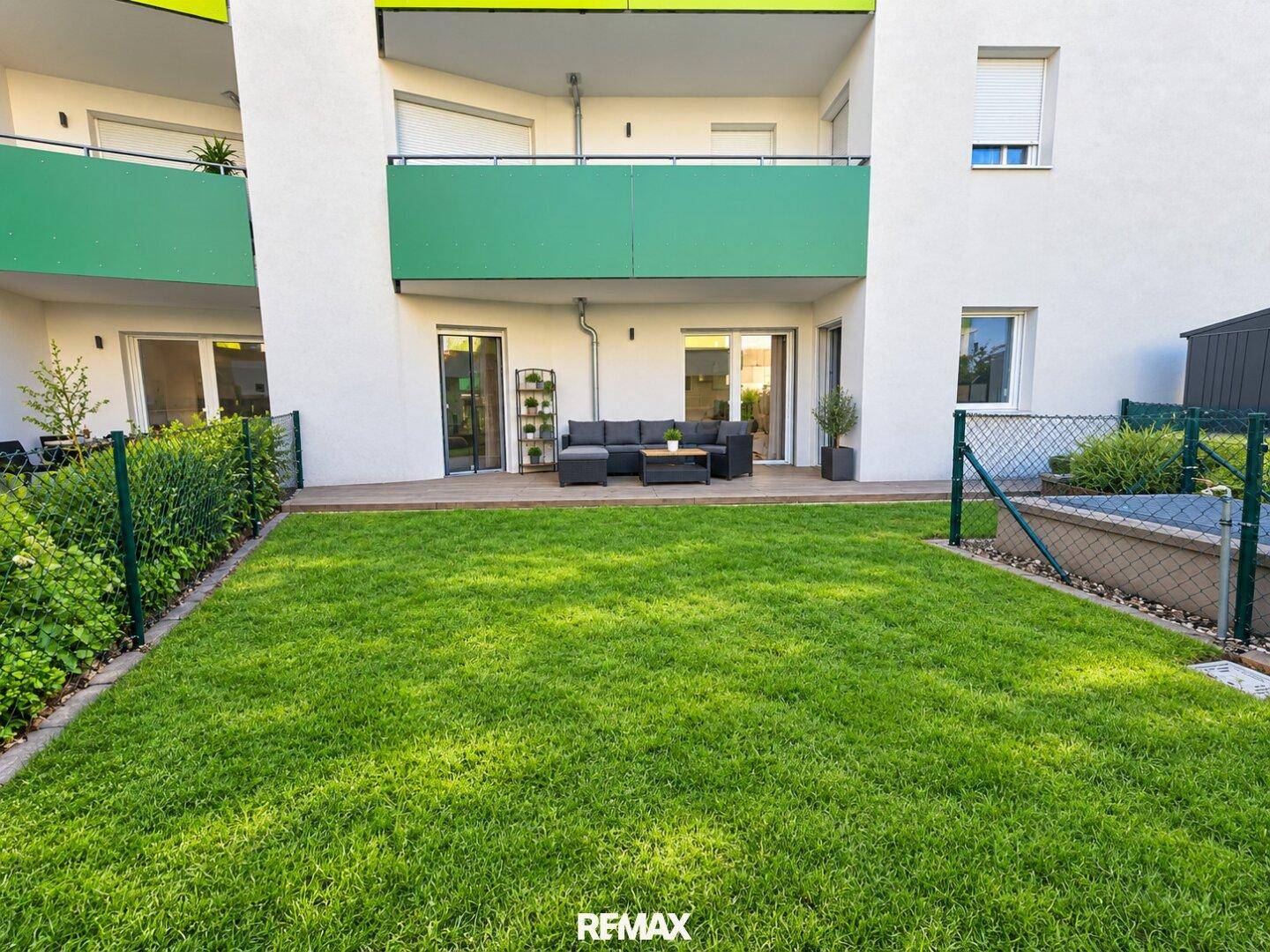Privater Gartenbereich mit Rasenfläche und angrenzender Terrasse, ideal zum Entspannen.