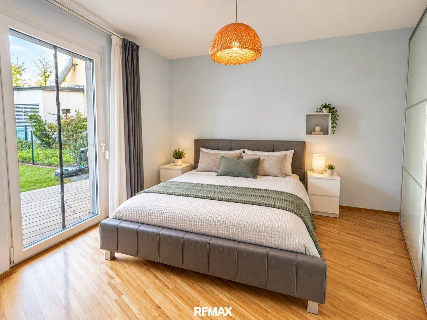 Gemütliches Schlafzimmer mit Doppelbett, hellem Holzboden und direktem Gartenzugang.