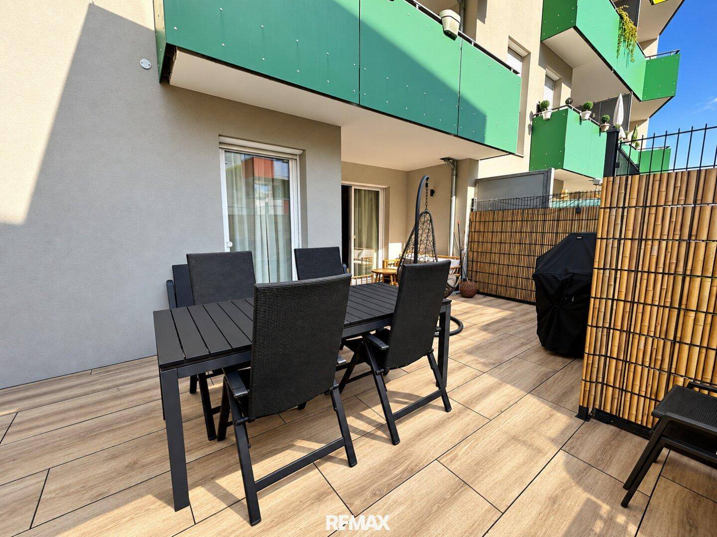 Große Terrasse mit Esstisch und Grillbereich, perfekt für Mahlzeiten und Unterhaltung im Freien.