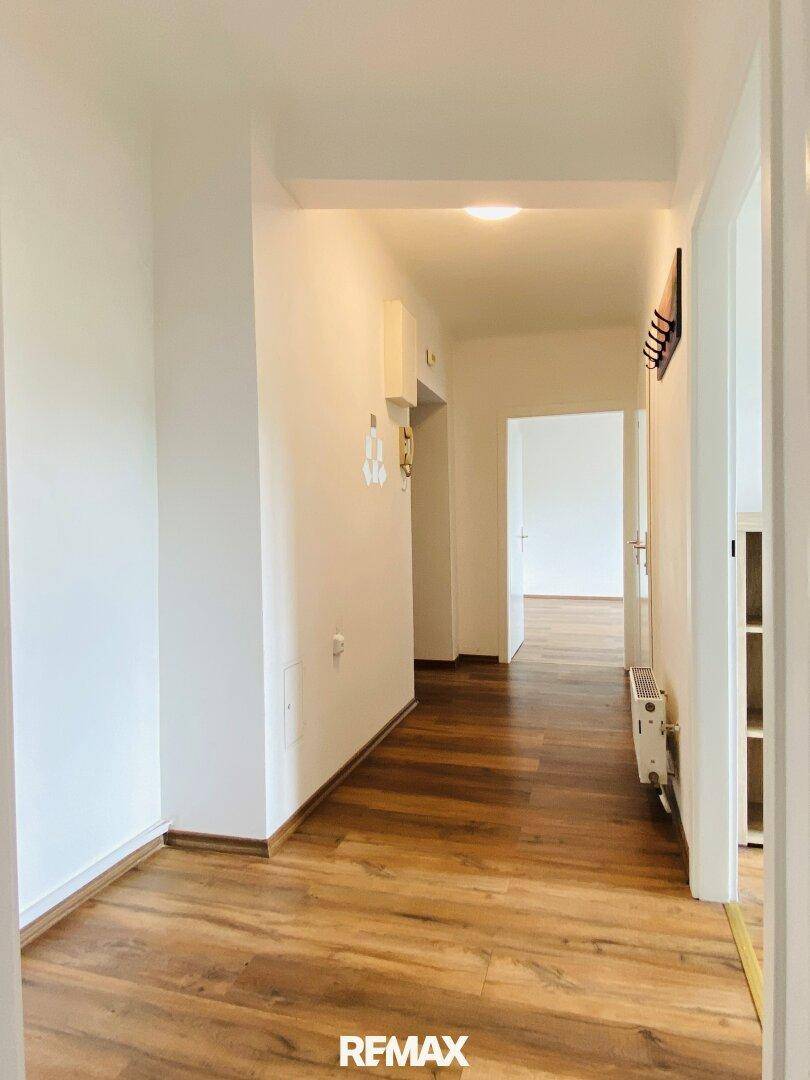 Geräumiger Eingangsbereich mit Garderobe und hellem Laminatboden, verbindet die Wohnräume miteinander.