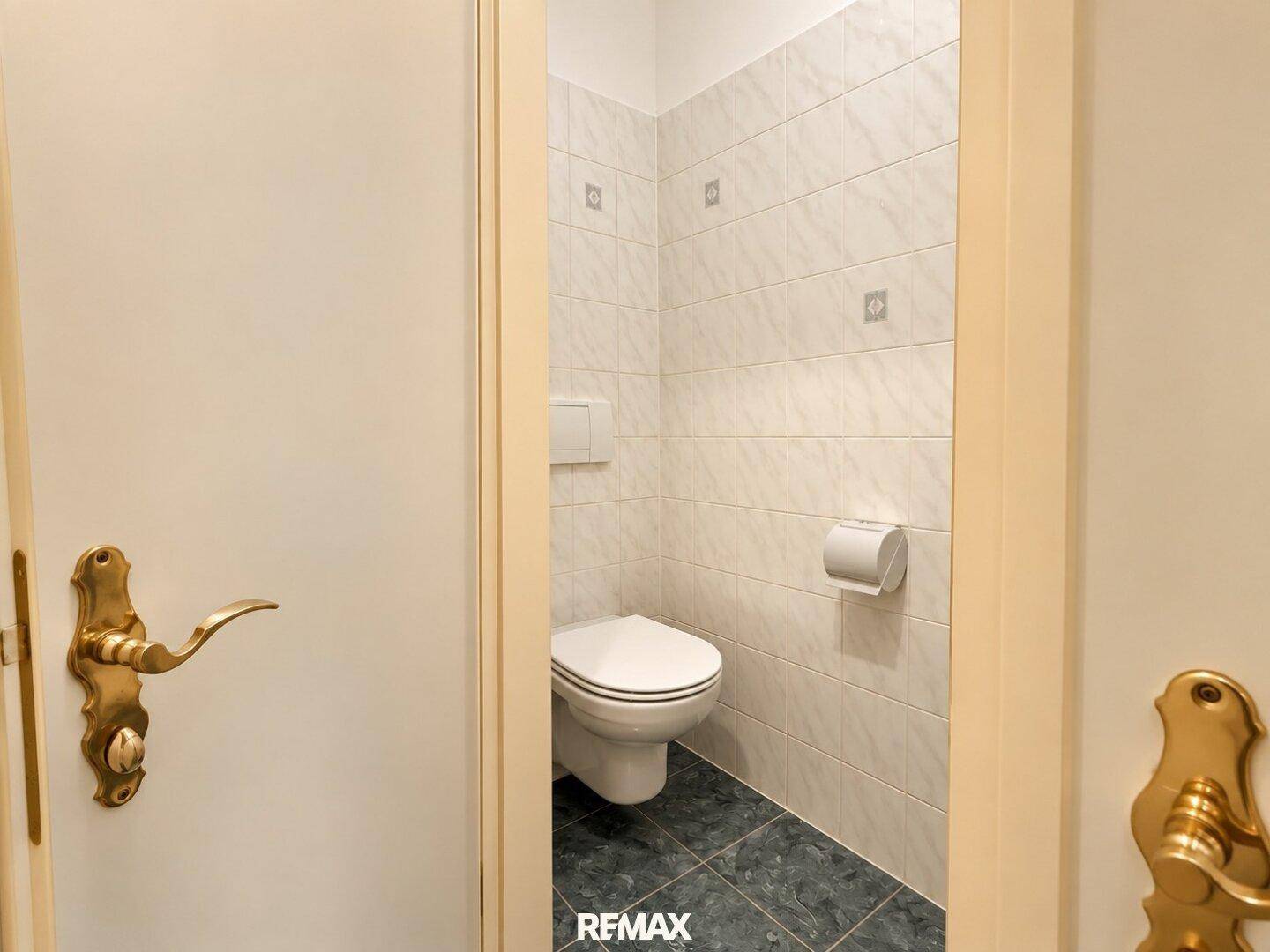Separates WC mit Wandtoilette und Fliesenboden, praktisch und sauber.