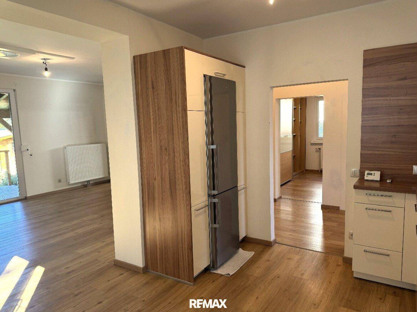 Blick von der Küche in den Wohnbereich mit integriertem Kühl-Gefrierschrank.