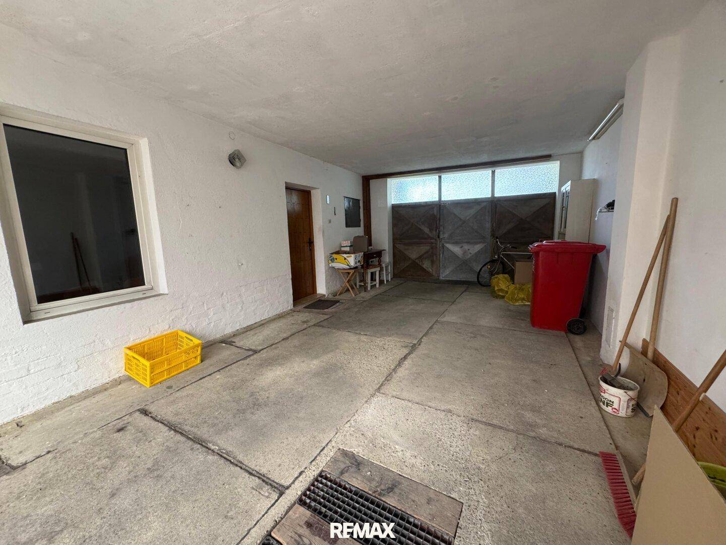 Geräumige Garage mit Betonboden und ausreichend Platz für Fahrzeuge und Lagerung.