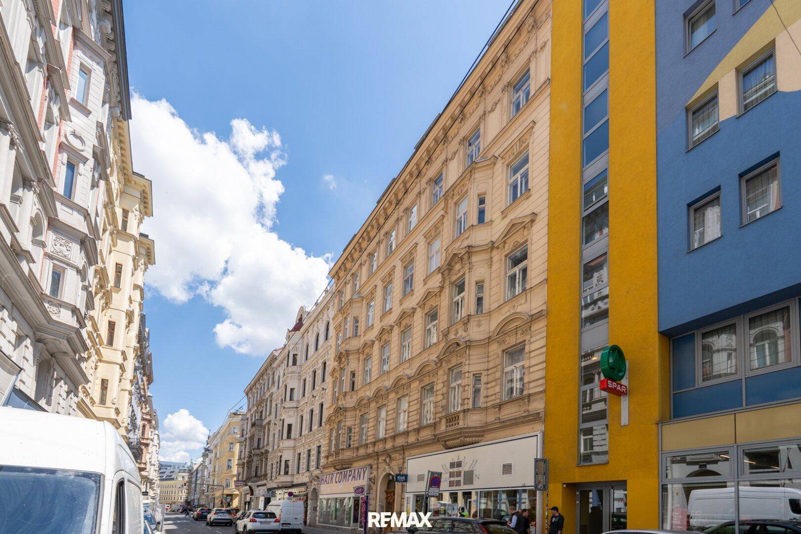 Historische Straßenansicht mit Altbau-Fassaden und einem modernen Gebäude daneben.