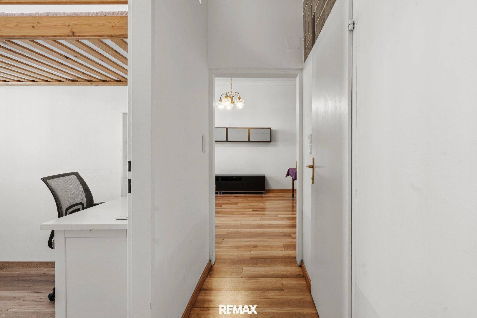 Heller Flur mit Holzboden, der zu den verschiedenen Zimmern der Wohnung führt.