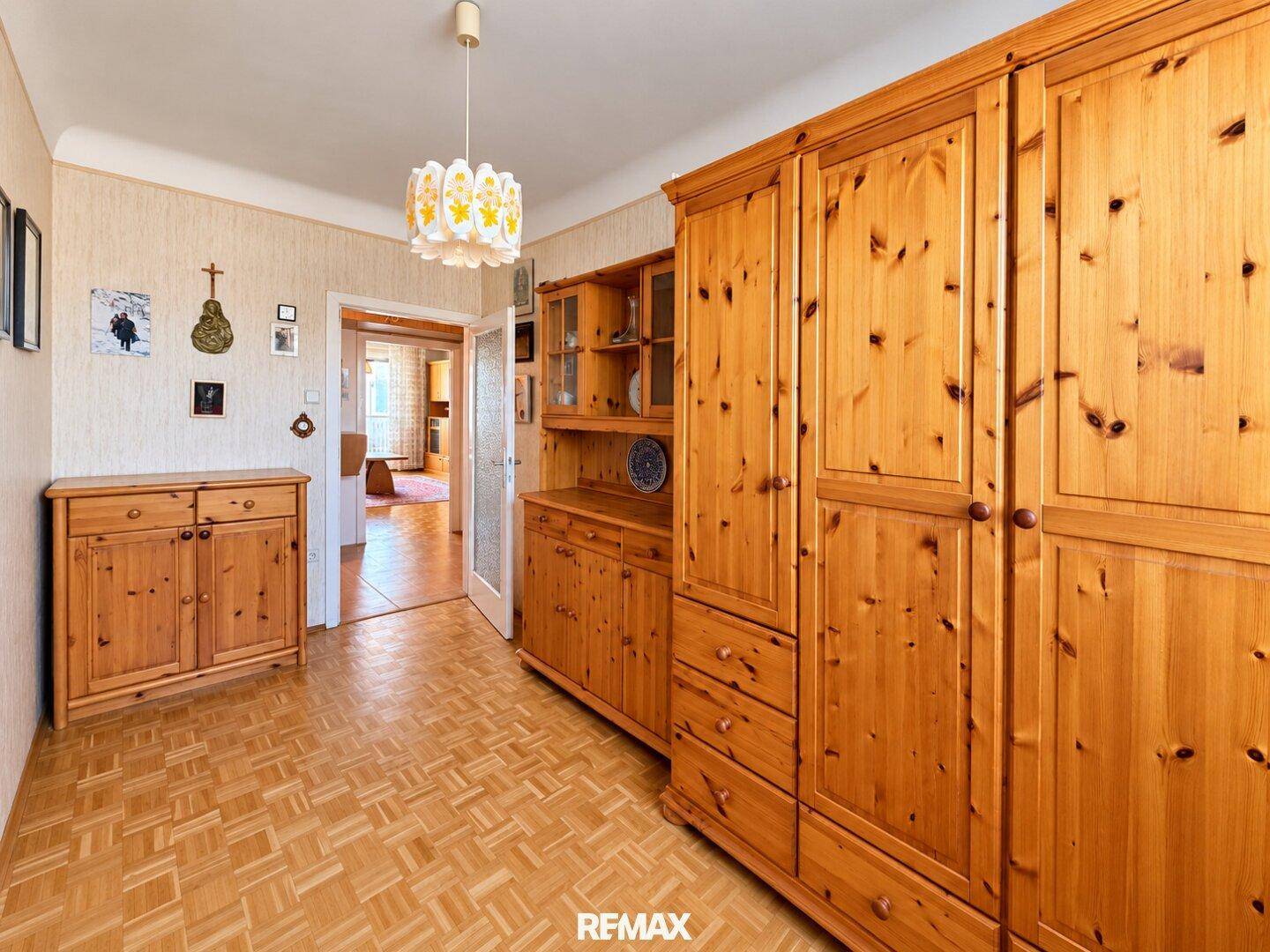 Flur oder Durchgangsbereich mit praktischen Holzschränken und Zugang zu weiteren Räumen.