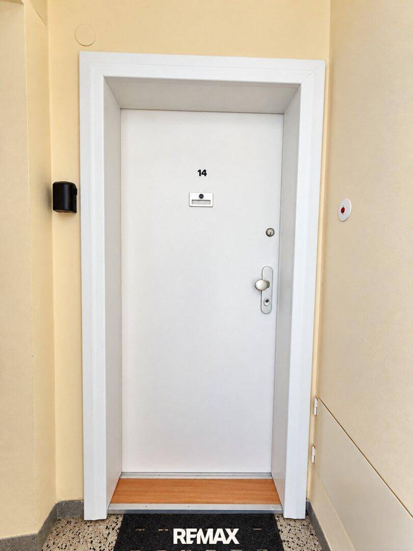 Weiße Eingangstür mit der Nummer 14, die den Zugang zur Wohnung markiert.