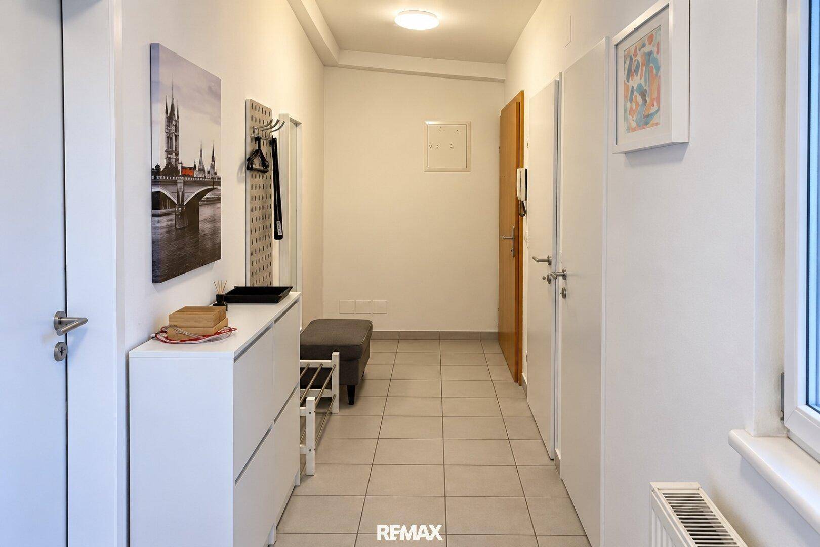 Heller Flur mit Fliesenboden, Garderobe und Schuhschrank.