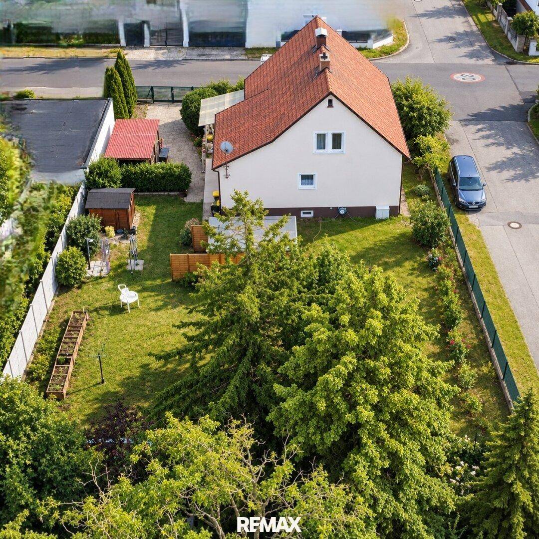 Vogelperspektive des Hauses mit großem Garten, Rasenfläche und einem kleinen Geräteschuppen.