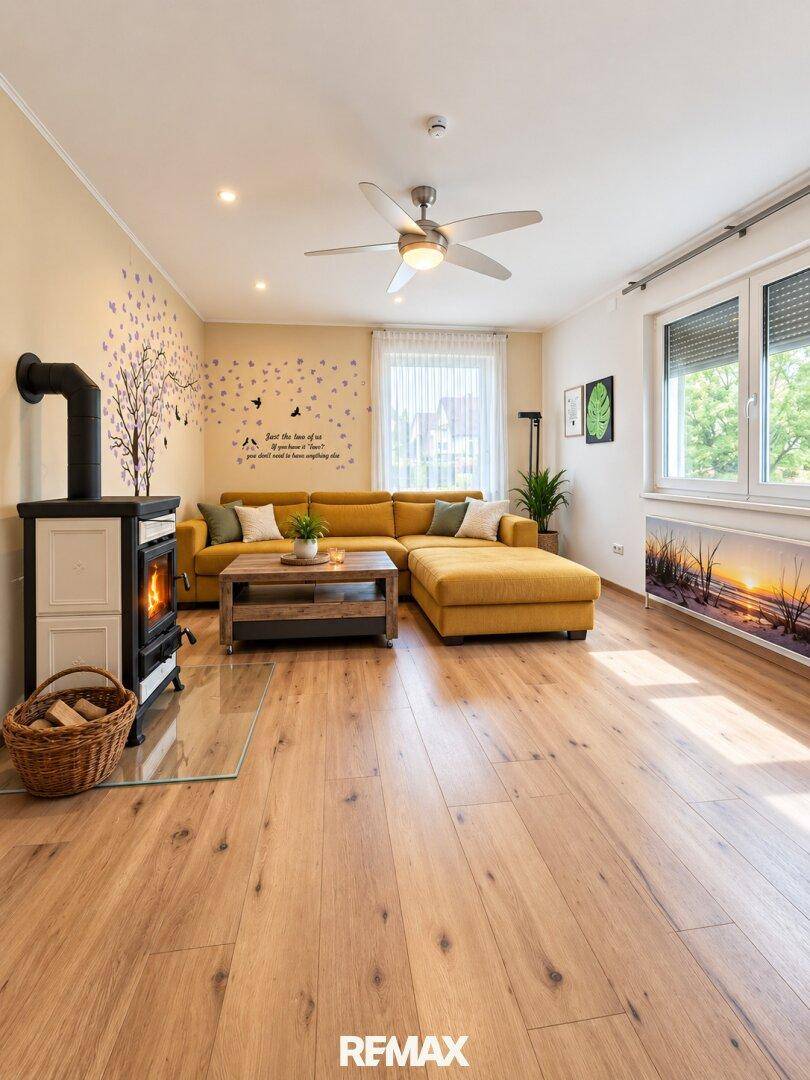 Gemütliches Wohnzimmer mit gelbem Sofa, Holzboden und einem modernen Holzofen.