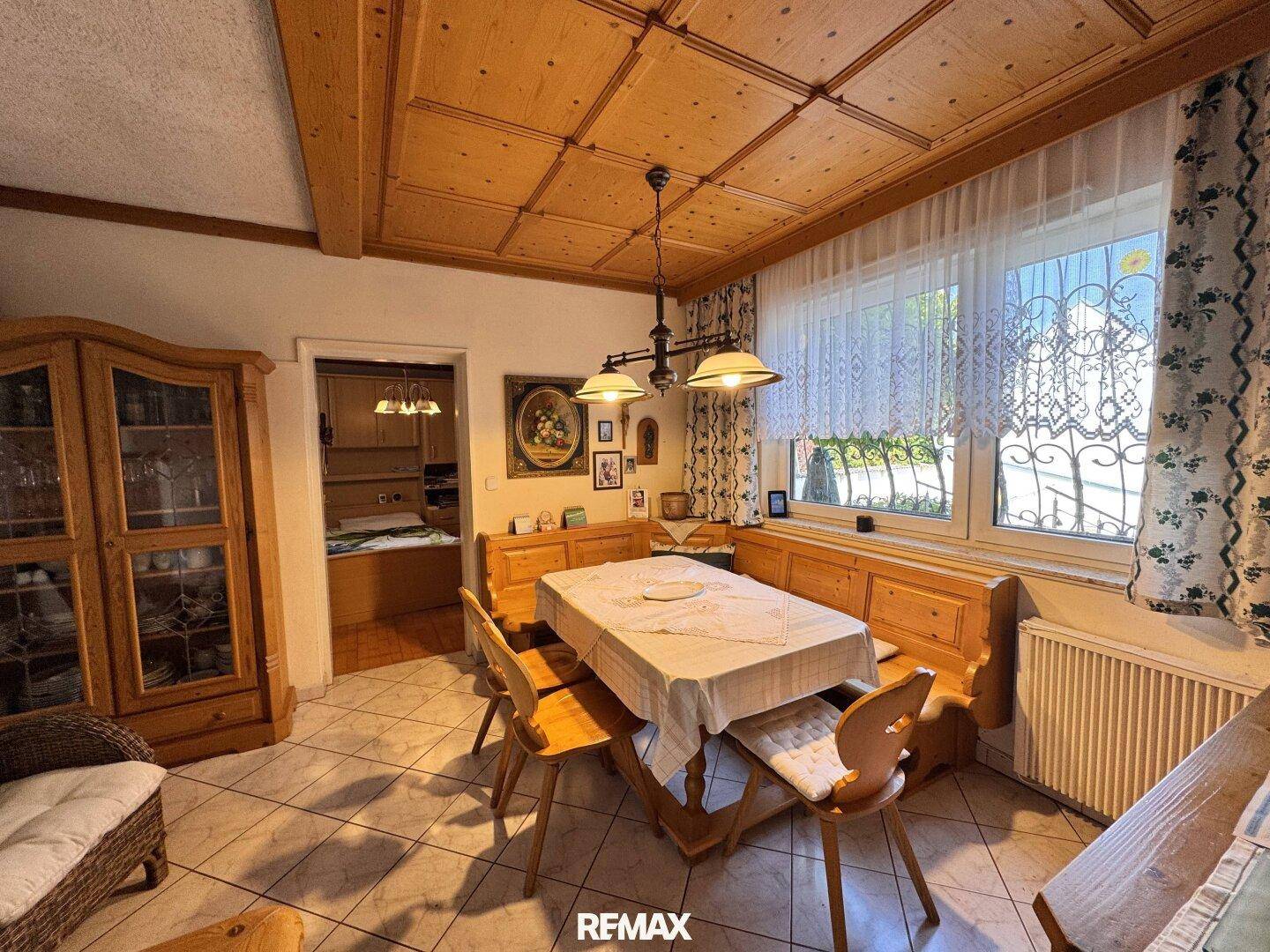 Gemütlicher Essbereich mit traditionellen Holzmöbeln, Eckbank und gefliestem Boden.