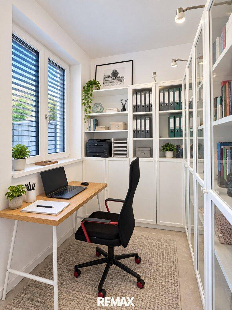 Helles Arbeitszimmer mit großem Fenster, Schreibtisch und Bücherregalen.