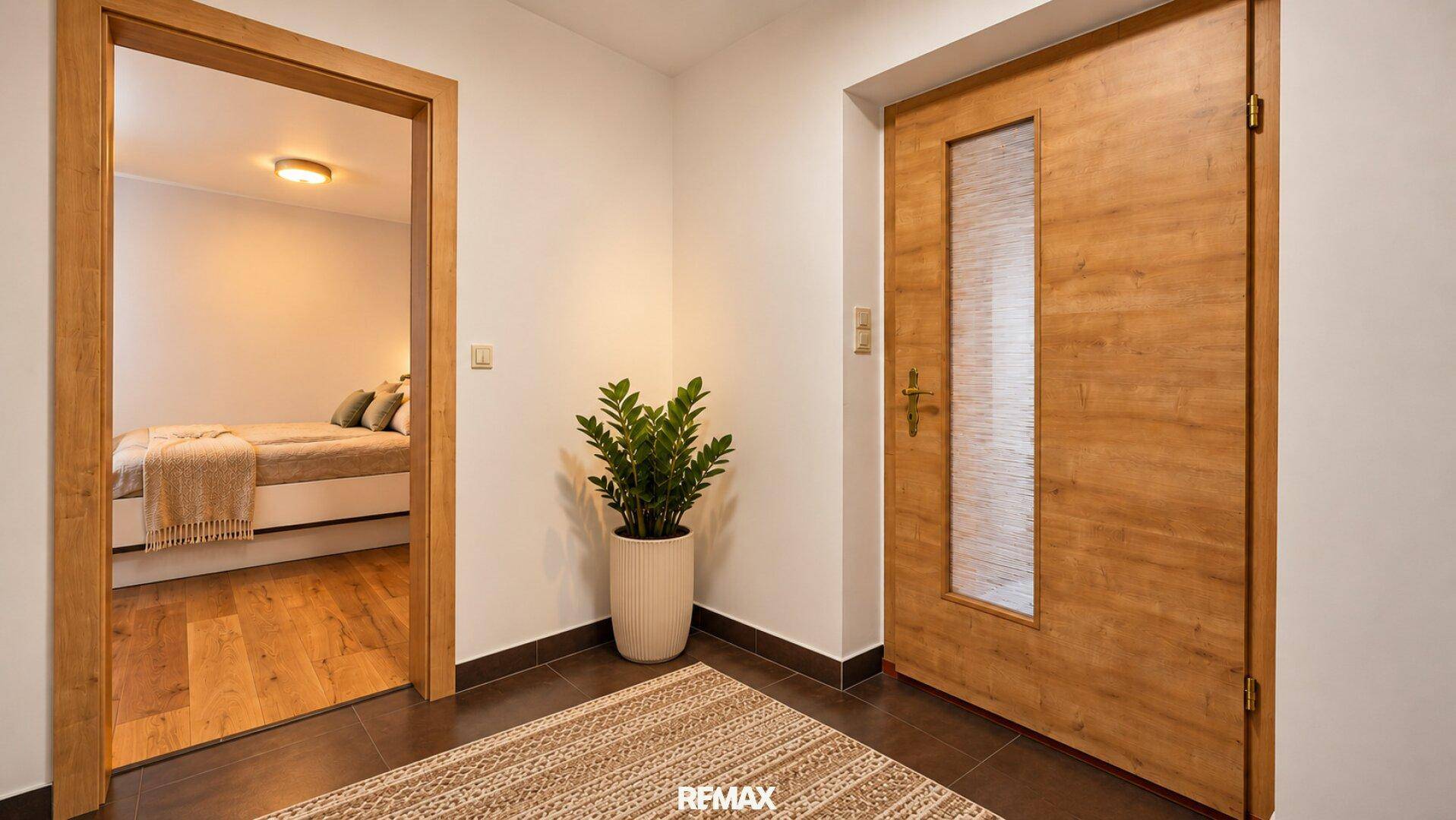 Heller Flur mit Holztür und Blick in ein angrenzendes Schlafzimmer, einladend gestaltet.