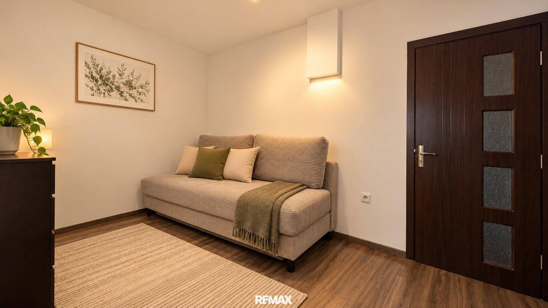 Gemütlicher Wohnbereich mit Sofa, Teppich und indirekter Beleuchtung für eine angenehme Atmosphäre.