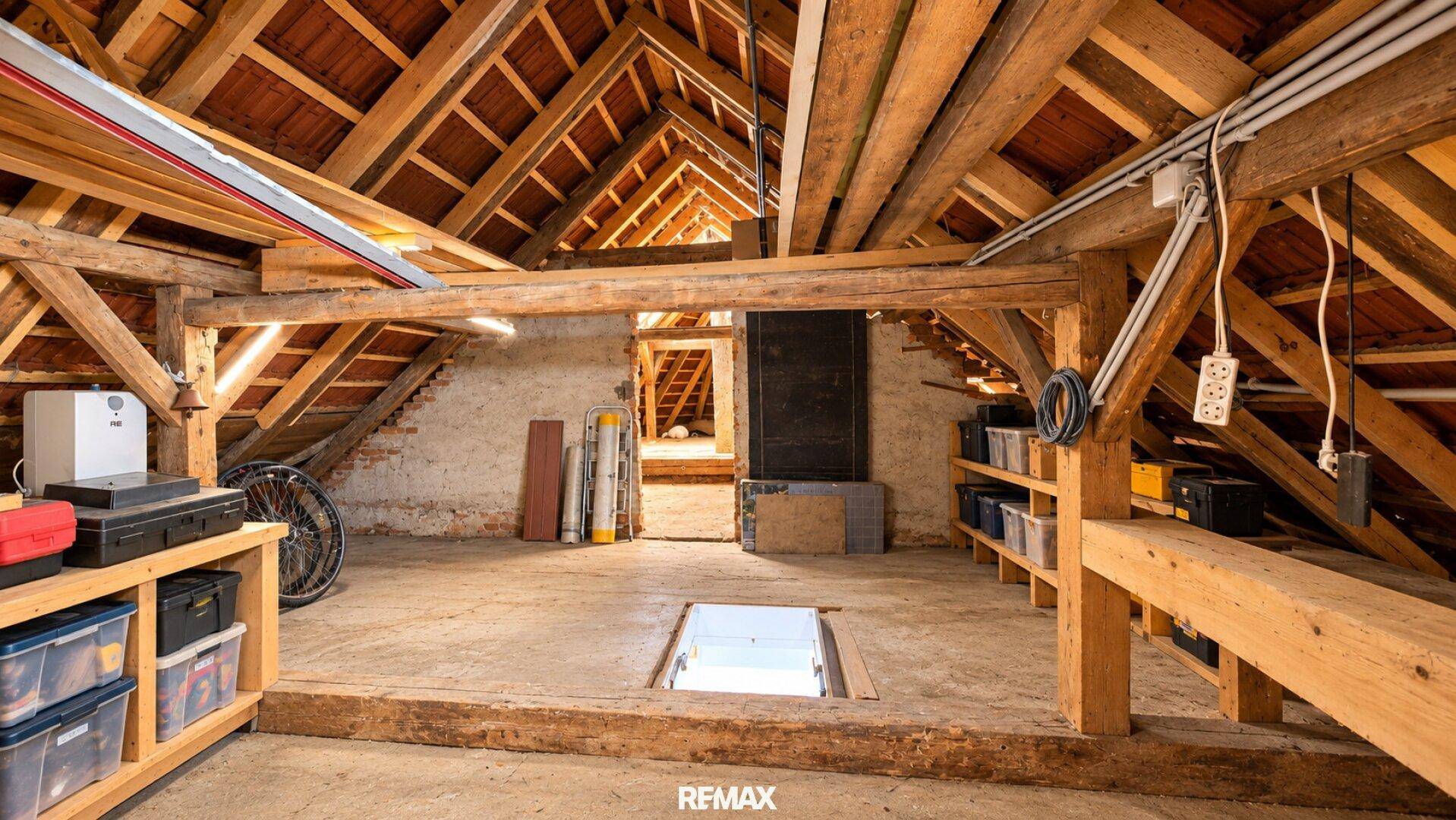 Geräumiger Dachboden mit sichtbaren Holzbalken und viel Stauraum, ideal für Lagerzwecke.