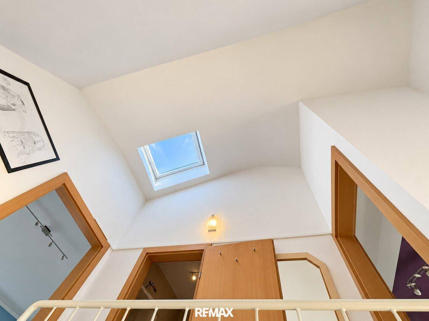 Heller Flur im Dachgeschoss mit Dachfenster und schrägen Decken.