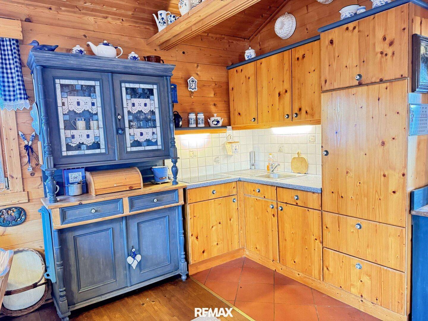Rustikale Küche mit Holzschränken, gefliestem Spritzschutz und Terrakotta-Bodenfliesen.