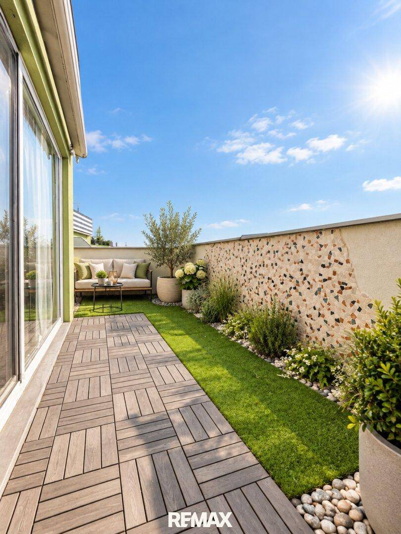 Kleine Gartenfläche auf einer Terrasse mit Holzboden und dekorativer Wand.