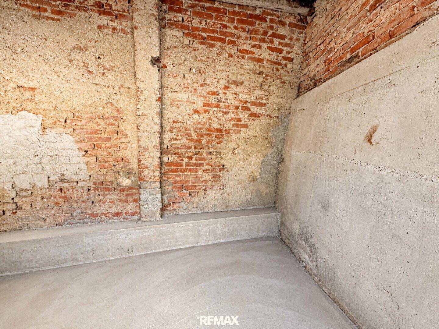 Rohbau-Kellerraum mit unverputzten Ziegelwänden und neuem Estrichboden, ideal für Lagerzwecke.