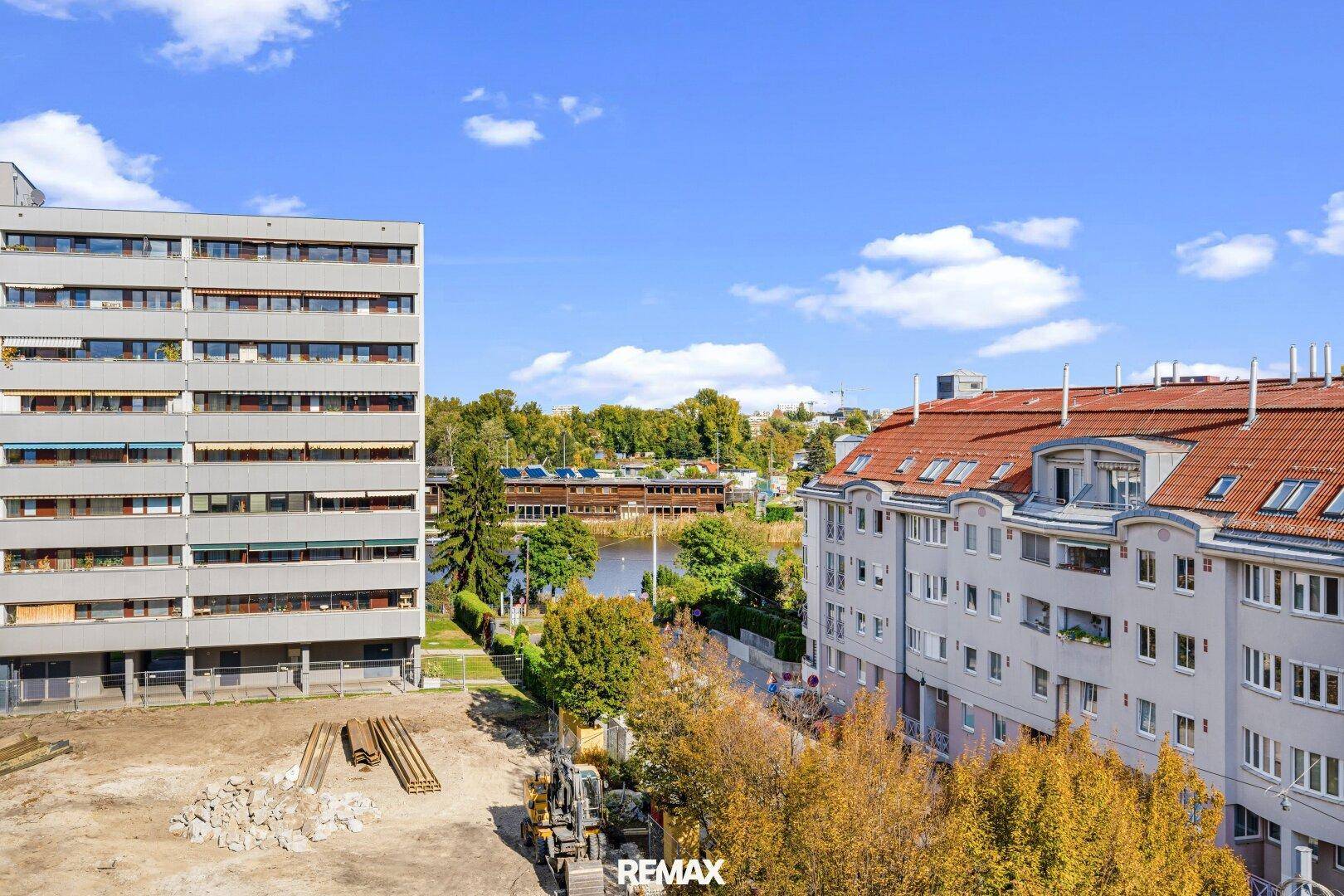 Panoramablick auf die Wohngegend mit Gebäuden, Baustelle und einem Gewässer.