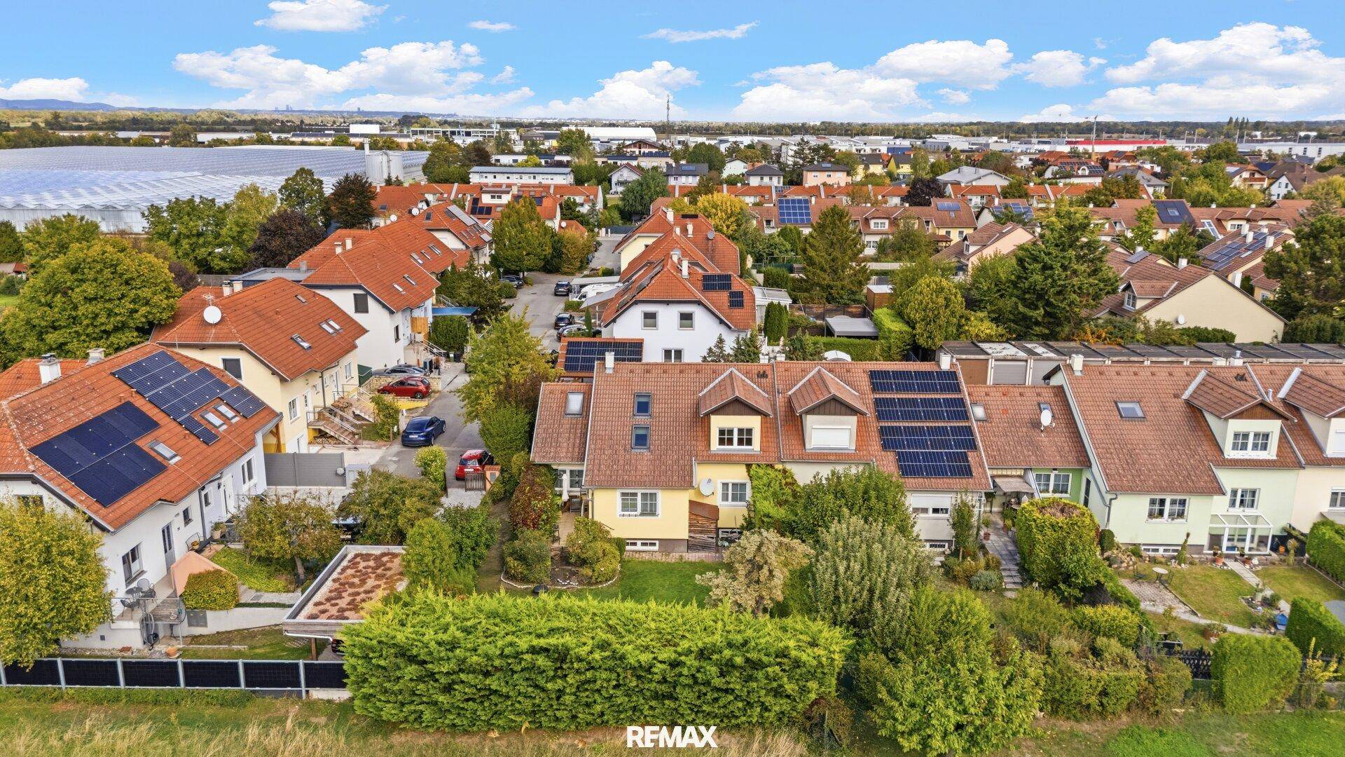 Weitläufige Luftaufnahme der Wohnsiedlung mit vielen Häusern und Grünflächen.