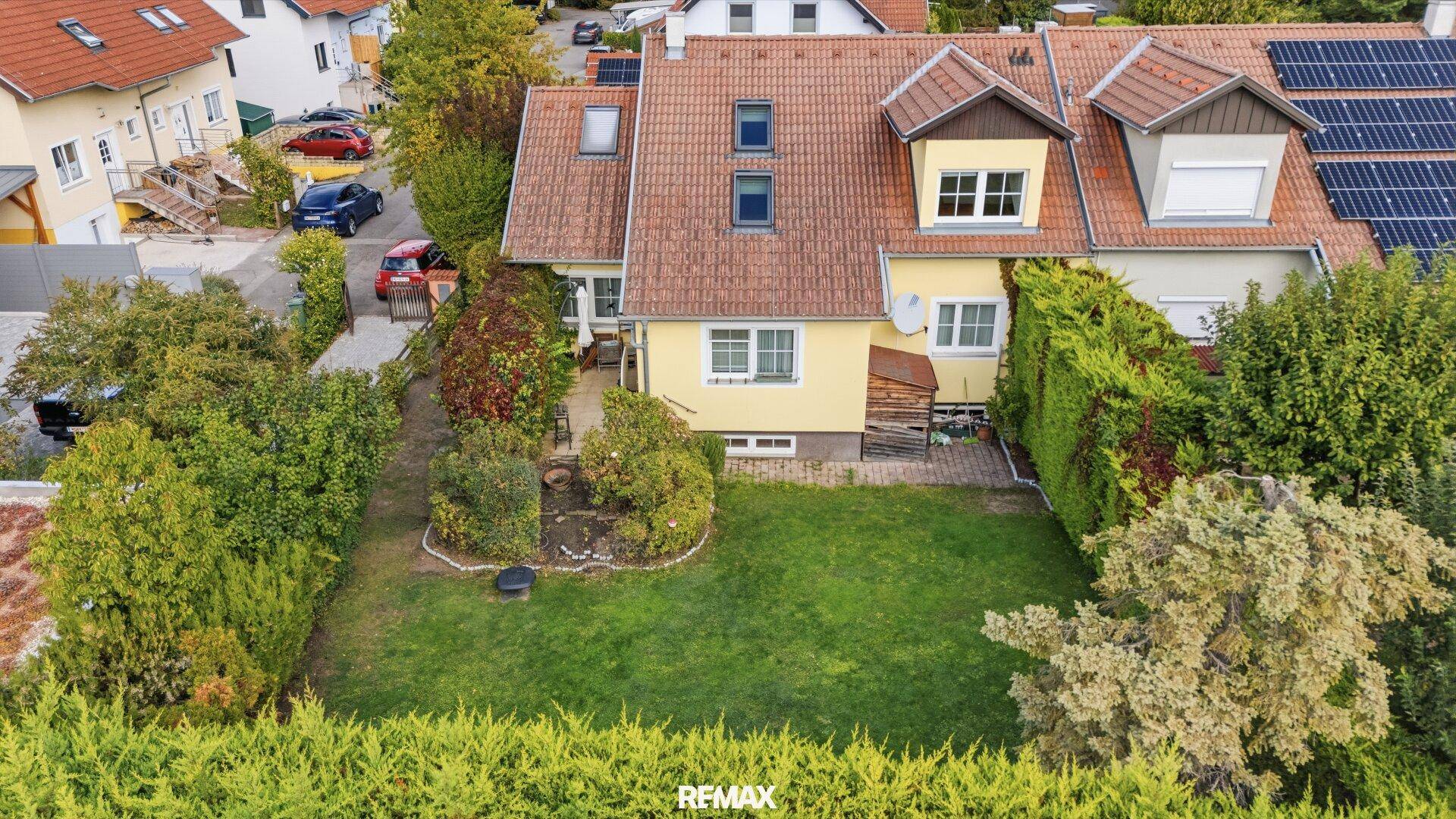 Luftaufnahme des Hauses mit Garten, Terrasse und umliegender Bebauung.